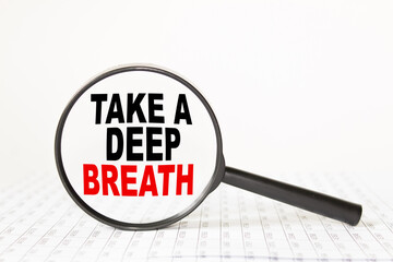 words TAKE A DEEP BREATH in a magnifying glass on a white background. business concept