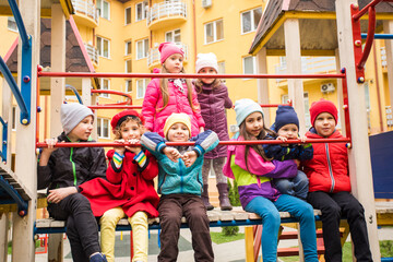 Cheerful kids at outdoor playground in early spring