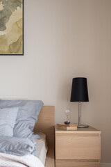 Wooden bedside table with black lamp