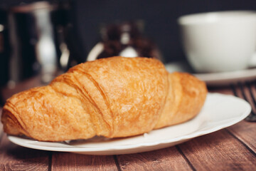 croissants in a plate a cup with a drink a meal dessert snack