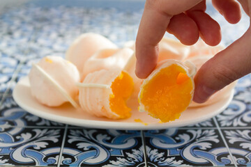 Hand taking a traditional portuguese sweet called Ovos Moles de Aveiro