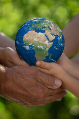 Family holding Earth planet in hands.Elements of this image furnished by NASA