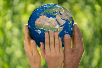 Family holding Earth planet in hands.Elements of this image furnished by NASA