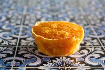 Traditional portuguese sweet bean pastry called Pastel de Feijao on portuguese tiles background