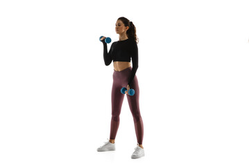 Fototapeta premium Dumbbells. Young caucasian female model in action, motion isolated on white background with copyspace. Concept of sport, movement, energy and dynamic, healthy lifestyle. Training, practicing.