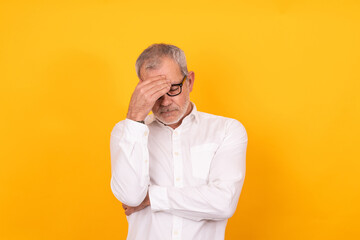 desperate senior adult man with hand on head isolated