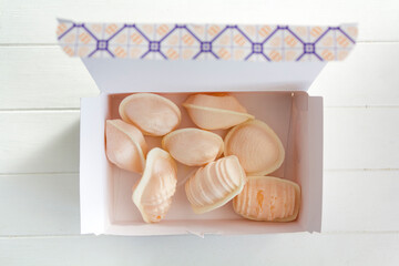 Top view of box with traditional portuguese sweet called Ovos Moles de Aveiro in white wooden table