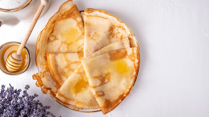 Pancakes with honey on a plate. Morning breakfast concept. Top view, text space