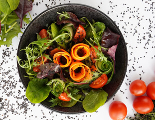 Fresh mixed vegetables salad in a bowl. Raw salad in black bowl on white background