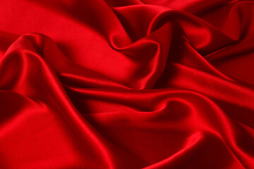 Red silk or satin luxury fabric texture can use as abstract background. Top view.