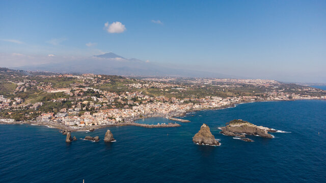Drone flight view of Acitrezza bay with Etna volcano in the background in Sicily Italy
