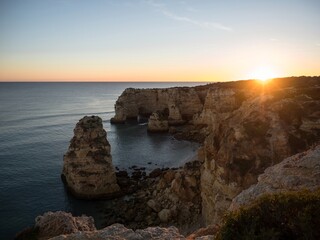 Sunset panorama view of rock cliff coast navy beach Praia da Marinha Caramujeira Lagoa Algarve...