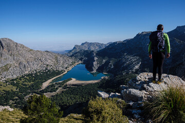 Naklejka premium hiker watching Gorg Blau reservoir, Escorca, Mallorca, Balearic Islands, Spain