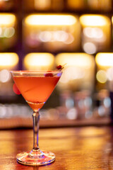 Strawberry juice mixed with alcohol soda in a cocktail glass in front of the vintage bar,...