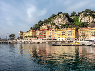Fototapeta na wymiar Immeubles aux couleurs chaudes en bord de mer dans le port Lympia de Nice sur la Côte d'Azur