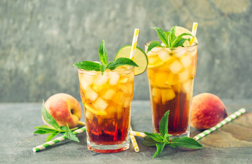 Peach ice tea with ice, lime and mint in the glass