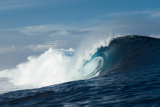 Blue wave breaking on a beach in sea