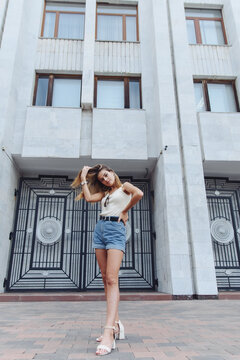 Outdoor full length vertical image of model in summer shorts and T-shirt. Stylish. Fashion concept