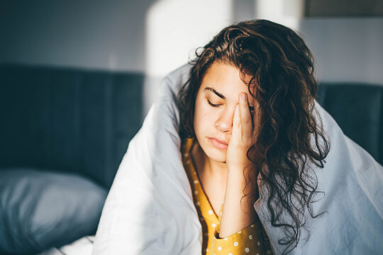 Unhappy woman in a bedroom.