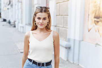 Portrait of a beautiful young woman walking in the street. Woman with beautiful earrings and...