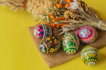 Colorful Easter eggs and palm ona yellow background