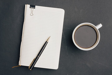 the dark background a Cup of coffee office Notepad handle the view from the top