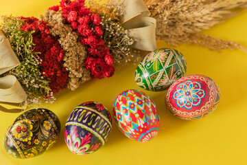 Colorful Easter eggs and palm on yellow background