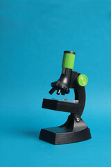 school microscope isolated on blue background. Science concept