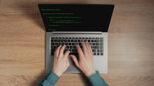 Timelapse of man's hands are typing commands of a laptop keyboard. A man is writing a program. The developer is coding. Code on the laptop screen. Concept of programming and development web.