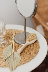 Mirror and hair brush with natural bristles on cosmetic table.