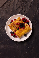 Rolled thin pancakes stuffed with cottage cheese and berries