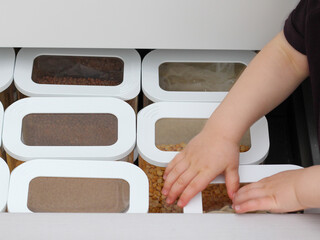 Child picking an item from storage hutch. Smart kitchen organization concept