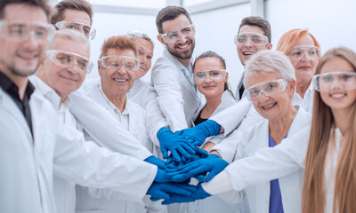 group of medical lab employees joining their palms together.
