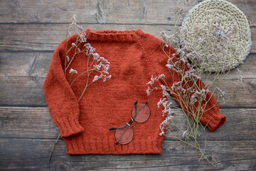 Red woolen handmade baby sweater on gray background