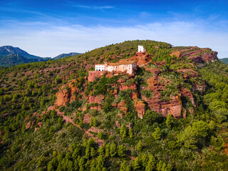 Fototapeta premium Aerial view of Mare de Deu de la Roca de Mont-roig in Spain, vast hilltop hiking destination with rocky climbing areas, panoramic views and a historic church