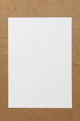 Template of white paper lies on light brown cloth background. Concept of business plan and strategy. Stock photo with empty space for text and design.