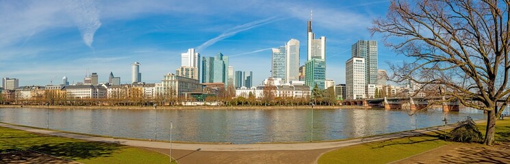 Panoramic picture from Main river bank over Frankfurt skyline with blue sky and sunshine