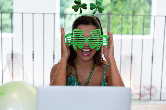 Caucasian woman celebrating st patrick's day making video call wearing deely boppers and glasses