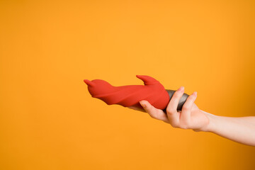 Sex gadgets and masturbation devices. Red dildo on orange background. sex toys: anal butt plugs,...