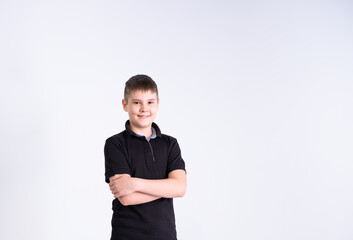 Portrait of boy teenager in black t-shirt looking at camera, smiling with positive feeling on his face on white background