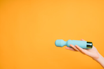 Blue vibrator or masturbation massager on an orange background. Flat Lay. Sex shop concept