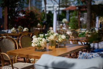Table setting with vases with white flowers on the terrace