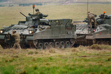 british army FV512 warrior MRV preparing to tow a stricken warrior FV510 light infantry fighting vehicle tank on Salisbury Plain, Wiltshire