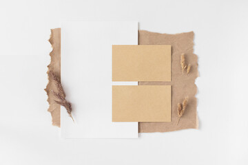 Paper rectangle frame mockup with pampas grass flat lay on white background top view. Minimalism composition in neutral tones. Empty blank template with copy space. Scandinavian style layout.