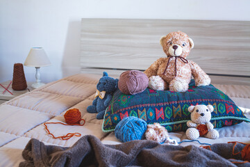 Cute wool teddy bear is lying in the bed