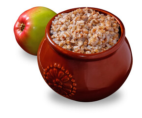 cooked buckwheat porridge in a clay pot and apple isolated on white background