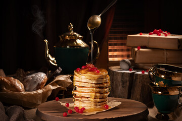 Pancakes with cranberries and pouring maple syrup