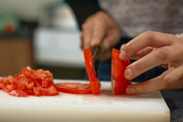 woman cutting vegetables tomato on cutting board