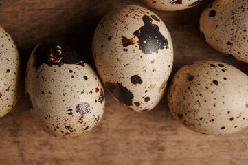 Obraz premium top view on quail eggs close up on wooden table. macro photo of raw quail eggs 