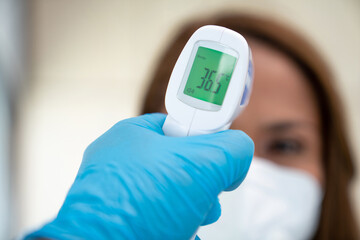 Contactless infrared thermometer indicating the temperature of a person